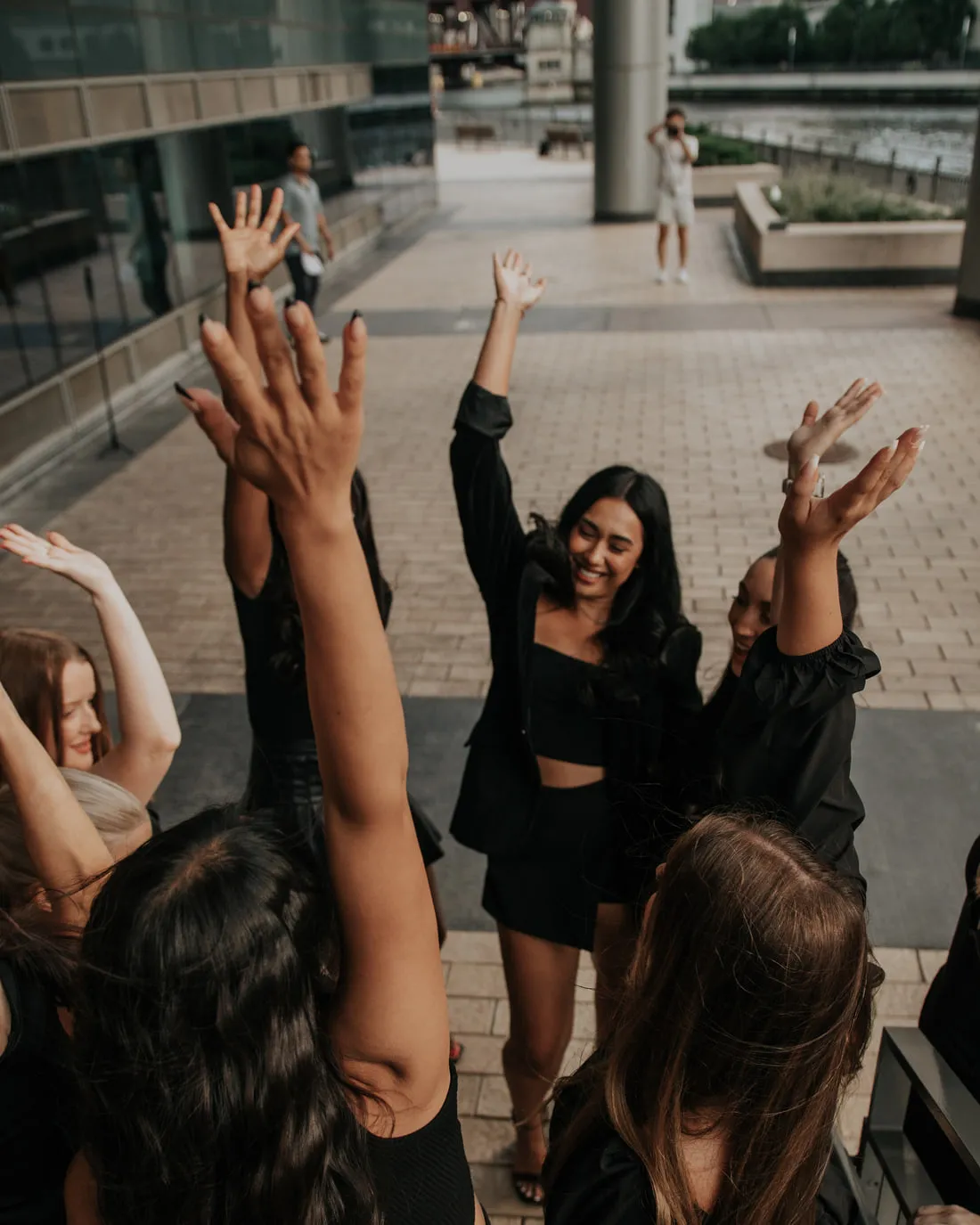 Members of the Moxie team laughing with their hands raised outdoors.